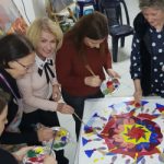 team smiling while painting together