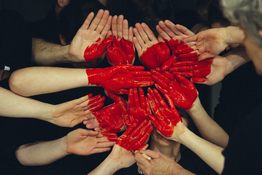 a heart created with painted hands, symbolising wellness packages for teams